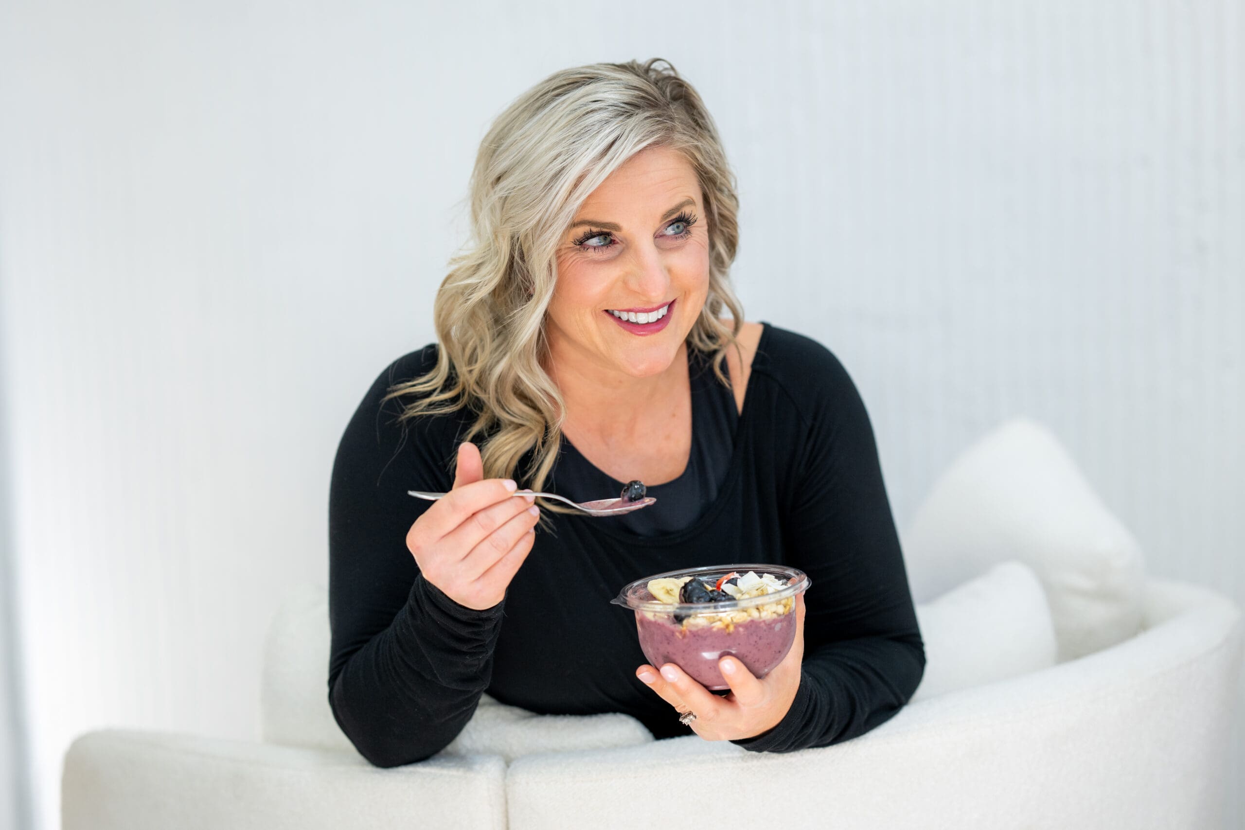 Woman enjoying a nourishing acai bowl, emphasizing the role of clean eating in detoxing for fertility.